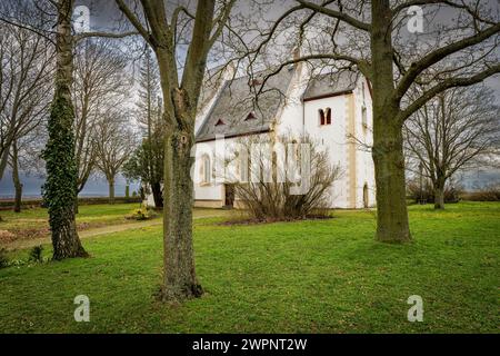 Protestant hilltop church in Udenheim, Rheinhessen, built in a secluded location on a hill surrounded by vineyards with an adjoining historic cemetery Stock Photo