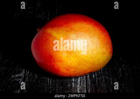 mango on black wood background Stock Photo
