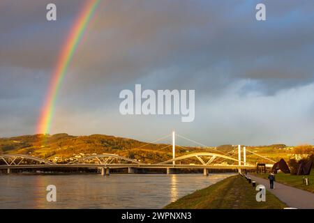 Linz, rainbow over river Donau (Danube), way at Donaulände, bridge Eisenbahnbrücke, bridge VOEST-Brücke (behind) in Zentralraum, Oberösterreich, Upper Austria, Austria Stock Photo