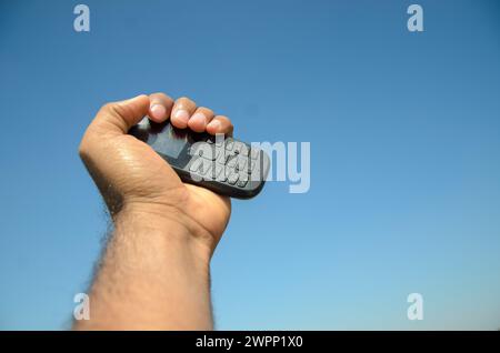 The old keypad phone holding up in hand Stock Photo