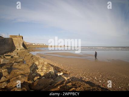 A metal detectorist scans the South Beach sands at Bridlington Stock Photo