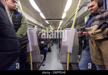 Passengers on travelling on a Merseyrail class 507 train showing passengers and the train interior Stock Photo