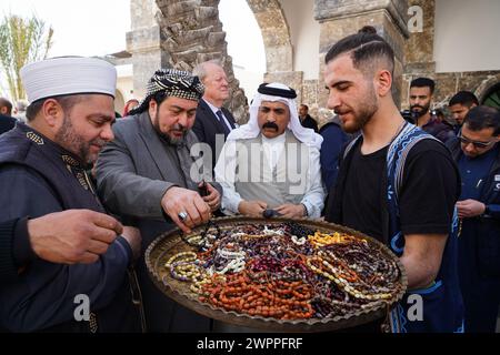 March 7, 2024, Mosul, Nineveh, Iraq: A young man distributes rosaries to people during the opening of Al-Masfi (Umayad) mosque in the old city of Mosul after completion of its restoration. The Umayad mosque also known Al-Masfi mosque is considered the oldest in Mosul, the second oldest mosque in Iraq, and the 5th oldest mosque in Islam. It dates back to the year 16 AH (637 AD). The mosque was damaged during the operations to liberate the city of Mosul from ISIS, and the mosque was reconstructed by the ALIPH organization in cooperation with LA GUILDE Association and Al-Tameer International Grou Stock Photo