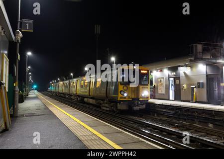 Merseyrail electrics class 508 third rail electric train 508104 at Ainsdale railway station, Southport, UK at night Stock Photo