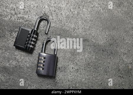 Steel combination padlocks on grey table, top view. Space for text Stock Photo