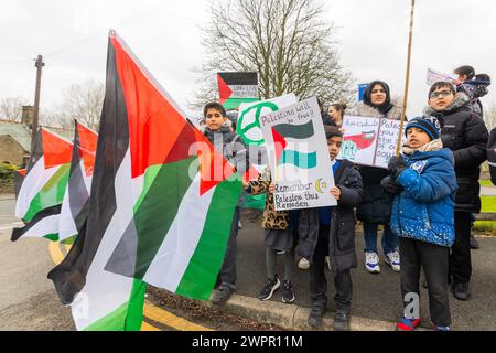 Bingley, UK. 08 MAR, 2024. Young boy holds Palestine will be free sign alongside other pupils at the Cottingley Village primary school. Story: Parents of students at Cottingley Village Primary School pulled their children out at 2PM on the 8th of march as part of a co-ordinated strike effort across multiple different schools across Yorkshire for Palestine. Credit Milo Chandler/Alamy Live News Stock Photo