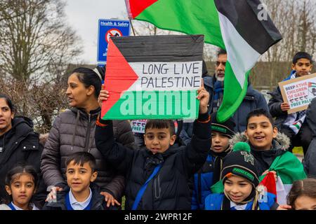Bingley, UK. 08 MAR, 2024. Young boy holds 'Long live palestine' sign alongside fellow students. Story: Parents of students at Cottingley Village Primary School pulled their children out at 2PM on the 8th of march as part of a co-ordinated strike effort across multiple different schools across Yorkshire for Palestine. Credit Milo Chandler/Alamy Live News Stock Photo