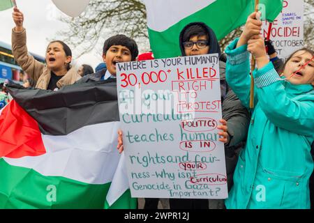 Bingley, UK. 08 MAR, 2024. Young boy holds sign that asks 'where is your humanity' alongside fellow students. Story: Parents of students at Cottingley Village Primary School pulled their children out at 2PM on the 8th of march as part of a co-ordinated strike effort across multiple different schools across Yorkshire for Palestine. Credit Milo Chandler/Alamy Live News Stock Photo