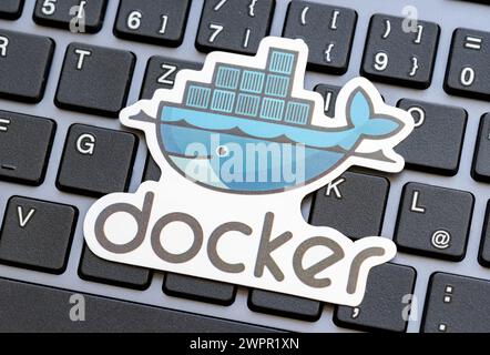 Docker logo placed over a laptop computer keyboard, Docker engine containers virtualization technology used in software development symbol, simple con Stock Photo