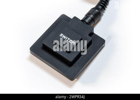 Simple generic black push button switch with the word SWITCH printed on top, object white background, cut out, nobody. Turning devices on and off, ele Stock Photo