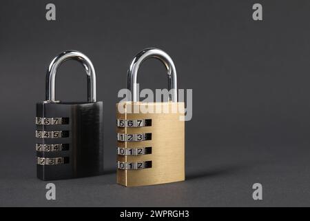 Steel combination padlocks on dark grey background, closeup. Space for text Stock Photo
