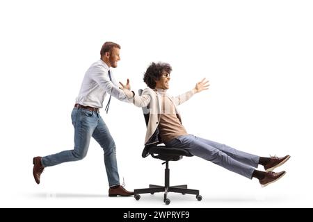 Office worker running and pushing a man on a desk chair isolated on white background Stock Photo