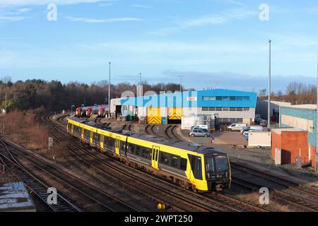 Merseyrail Stadler class 777 3rd rail electric train 777030  at Chester passing the CAF train maintenance depot with class 197's stabled Stock Photo