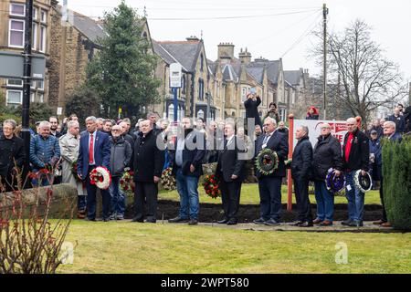 Barnsley, UK. 09 MAR, 2024. People hold wreathes ready to be laid outside the Barnsley National Union of Mineworkers hall in Barnsley, comomorating those who lost their lives during the miners strikes 40 years since the strikes.  Credit Milo Chandler/Alamy Live News Stock Photo