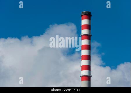 Chimney of a power plant in Sines, red, white, blue sky, power plant, energy, environment, climate, Co2, atmosphere, air pollution, exhaust fumes Stock Photo