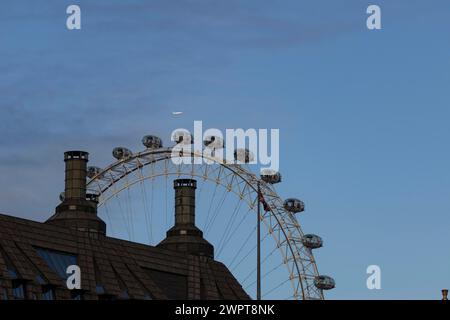 Airbus A319-100 aircraft of British airways in flight over the pods of the London Eye or Millennium Wheel, London, England, United Kingdom Stock Photo