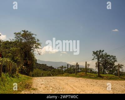 A rural gravel road, in a fairly clear blue sky morning, in the eastern Andean mountains of central Colombia, near the Iguaque mountain. Stock Photo