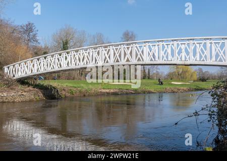 View of Wisley golf club and golf course with golfers playing, Surrey, England, UK, with a white footbridge over the River Wey Stock Photo