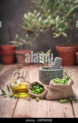 Healthy and tasty olives with mortar and twig. Freshly picked green olives. Stock Photo