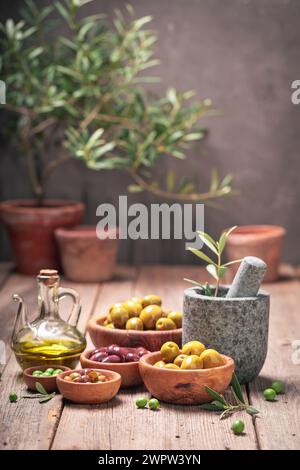 Raw and fresh olives with mortar and twig. Freshly picked green olives. Stock Photo