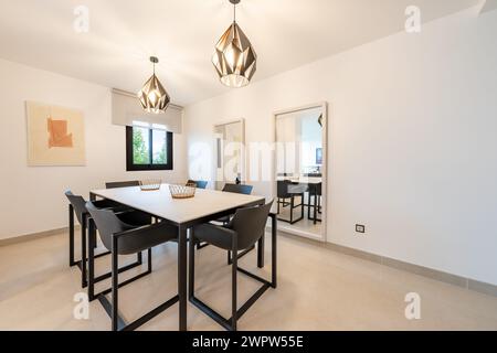 a large dining table surrounding by large mirrors in mediterranean apartment Stock Photo