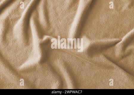 Fluffy gentle pastel beige fabric with waves and folds. Soft pastel textile texture. Abstract background. Stock Photo