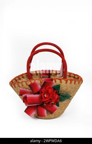 Straw children's bag decorated with artificial flowers on a white background Stock Photo