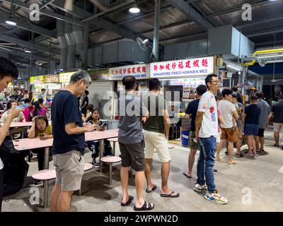 Customers queuing at one of Singapore's famous vendors at the hawker centers Stock Photo