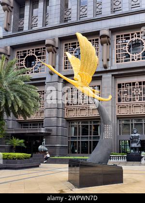 The Golden Crane statue at Parkview Square in Singapore. The  golden crane has its head lifted, its wings in pre-flight mode pointing toward China Stock Photo