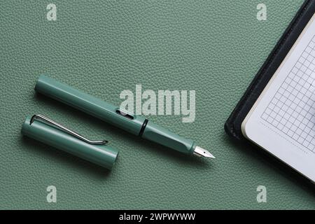 Fountain pen and notebook green leather background Stock Photo