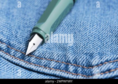 Green fountain pen is back pocket blue jeans Stock Photo