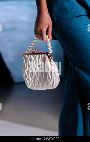 Fashionable details of a white clutch with beads in a woman's hand. Elegant clothing and accessories Stock Photo