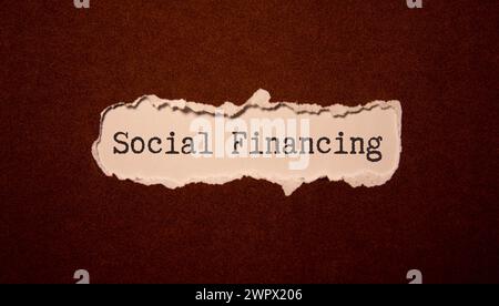 The text social security written on a lettered board with a piggy bank and a calculator in the composition. Wooden table Stock Photo