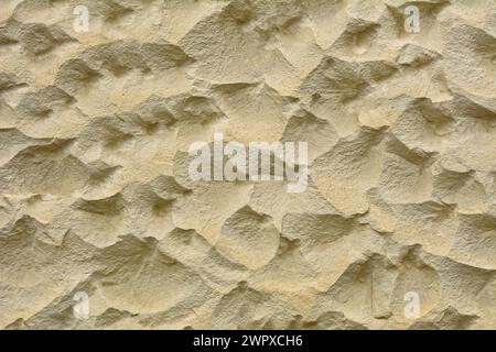 Beige stone wall with wavy surface Stock Photo