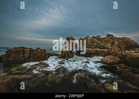 Long exposure of waves passing through the Kissing Rocks in Pacific Grove, California Stock Photo