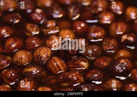Dipping of natural hazelnuts in pure rum for softening before making cookie  dough Stock Photo