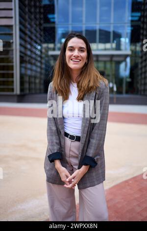 Portrait of successful Caucasian nice woman in suit posing smiling looking happy at camera outdoor. Stock Photo