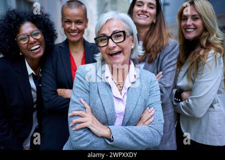 Portrait successful women business in suits looking laughing at camera with arms crossed outdoor. Stock Photo
