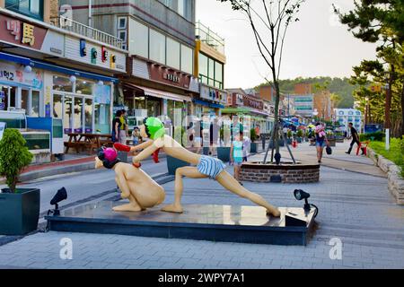 Yangyang County, South Korea - July 30, 2019: Late afternoon on the promenade at Naksan Beach, featuring statues of two women bathing each other, with Stock Photo