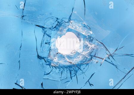 A bullet hole in a car's tinted glass close-up. Stock Photo