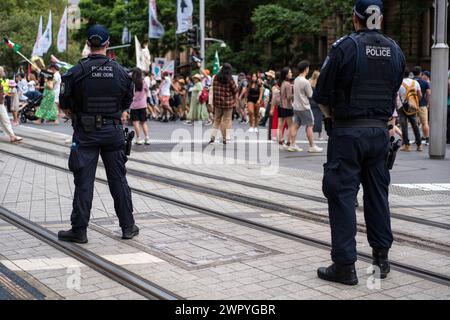 Police monitor demonstrators during a Sydney march supporting Palestinians in the Gaza War. Stock Photo