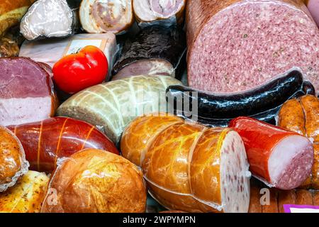 Various sausages, hams and gammon on the counter of butcher shop. Sausages products close-up. Stock Photo