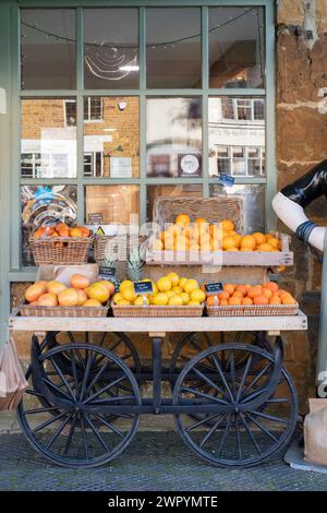 Oranges, lemons, grapefruit for sale on a cart outside Eagles Fine Foods shop. Deddington, Oxfordshire, England Stock Photo