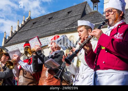 Imst: Imster Schemenlaufen (carnival), church Imst in background, Stadtmusik (town music band) in Imst, Tirol, Tyrol, Austria Stock Photo