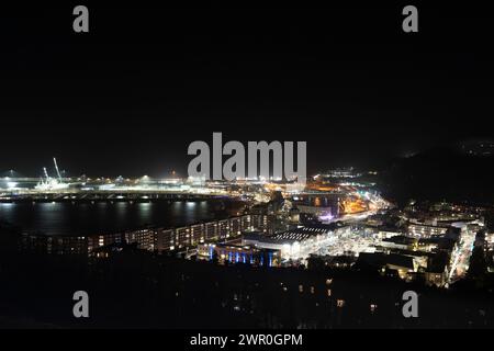 Dover city, beach and port at night from a high viewpoint at Dover castle. Foreground shows the St James Retail and leisure Park Shopping Center. Stock Photo