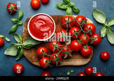 Tomato paste, sauce, ketchup and cherry tomatoes on branches and basil, top view Stock Photo