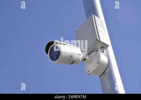 IP CCTV camera installed on a metal pole against a blue sky. Stock Photo