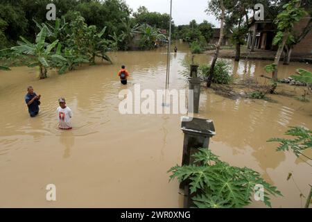 Sragen, Indonesia. 10th Mar, 2024. People wade through floodwater after heavy rain and overflow of Bengawan Solo River at Pandak village in Sragen district, Central Java, Indonesia, on March 10, 2024. Credit: Bram Selo/Xinhua/Alamy Live News Stock Photo