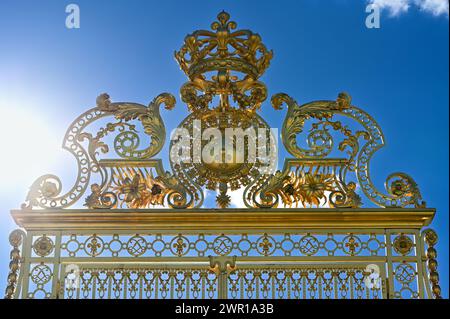 Versailles, Paris, France, June 30, 2022. Gorgeous detail of the golden gate of the royal palace. The late afternoon light enhances its brilliance. Stock Photo