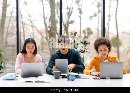 Students focused on studying with laptops and tablets Stock Photo